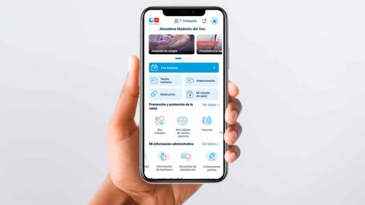 Mano sostiene un móvil con la app Tarjeta Sanitaria Virtual de la Comunidad de Madrid, que mostrará alertas personalizadas de calor extremo