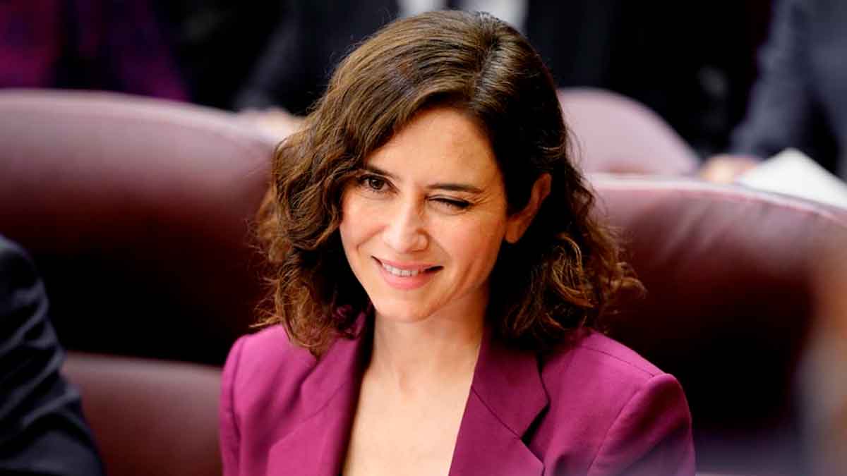 La presidenta de la Comunidad de Madrid en un pleno con chaqueta color magenta, relacionada con la jubilación parcial de docentes concertados
