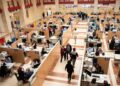 Oficina de la Agencia Tributaria llena de contribuyentes preparando y presentando la declaración de la Renta 2024/25 antes de la fecha límite