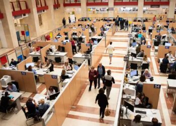 Oficina de la Agencia Tributaria llena de contribuyentes preparando y presentando la declaración de la Renta 2024/25 antes de la fecha límite