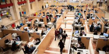 Oficina de la Agencia Tributaria llena de contribuyentes preparando y presentando la declaración de la Renta 2024/25 antes de la fecha límite