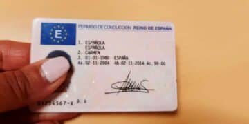 Mano sosteniendo un permiso de conducir español, renovación gratis del carnet para mayores de 70 anunciada por la DGT