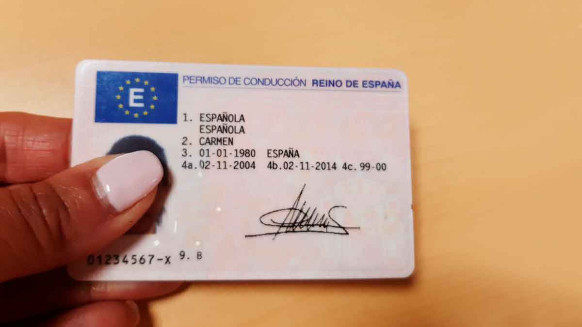 Mano sosteniendo un permiso de conducir español, renovación gratis del carnet para mayores de 70 anunciada por la DGT
