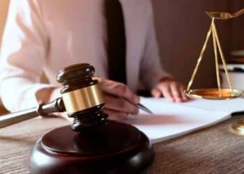 Mazo y balanza ante abogado redactando sentencia del Tribunal Supremo que anula el cambio de jornada a fines de semana