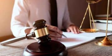 Mazo y balanza ante abogado redactando sentencia del Tribunal Supremo que anula el cambio de jornada a fines de semana