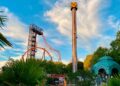 Torre de caída libre y montaña rusa del Parque de Atracciones de Madrid al atardecer, vistas desde la zona de acceso principal