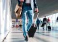 Joven con maleta recorriendo un aeropuerto, representación visual de la ayuda EURES de 1.000 € para trabajar y formarse en Europa