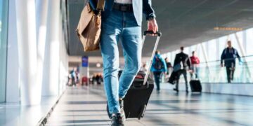 Joven con maleta recorriendo un aeropuerto, representación visual de la ayuda EURES de 1.000 € para trabajar y formarse en Europa