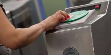 Mano de usuario validando la tarjeta de transporte en un lector del Metro de Madrid
