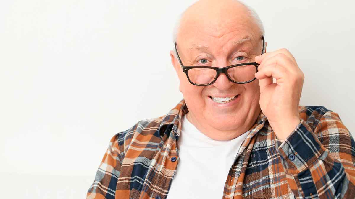 Jubilado sonriente con camisa de cuadros, ejemplo de estrategia para aumentar ingresos mensuales tras la jubilación