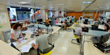 Funcionarios atienden al público en una oficina de la Administración, reflejando la mayor carga laboral que el Supremo liga a la revisión salarial