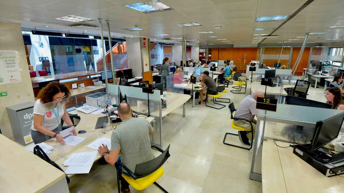 Funcionarios atienden al público en una oficina de la Administración, reflejando la mayor carga laboral que el Supremo liga a la revisión salarial