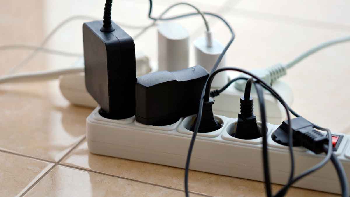 Regleta sobrecargada con cargadores y cables, ejemplo del riesgo de incendio que evita el gadget de Amazon