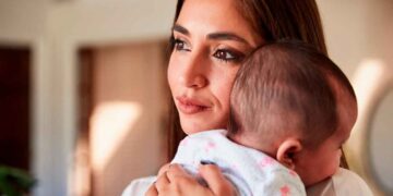 Madre joven con su bebé en brazos, símbolo de los nuevos incentivos y la bonificación por maternidad para empresas