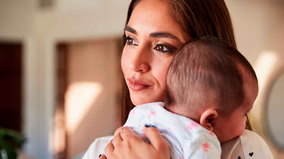 Madre joven con su bebé en brazos, símbolo de los nuevos incentivos y la bonificación por maternidad para empresas