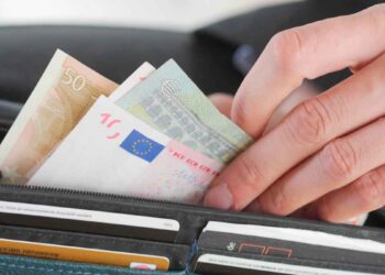 Mano extrayendo varios billetes de euro de una cartera, símbolo del límite de 100.000 € en efectivo impuesto por Hacienda