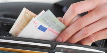 Mano extrayendo varios billetes de euro de una cartera, símbolo del límite de 100.000 € en efectivo impuesto por Hacienda