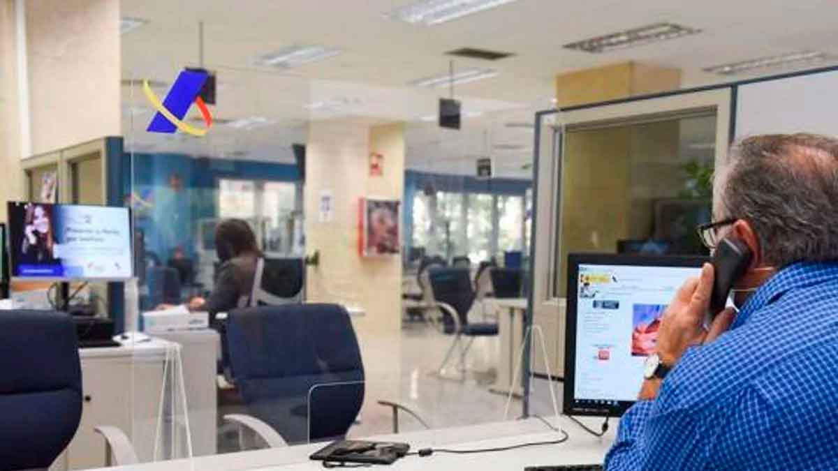 Empleado de la Agencia Tributaria asesorando a propietarios de vivienda sobre obligaciones fiscales en la Renta 2024-2025