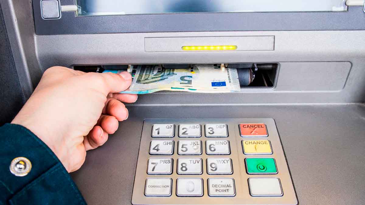 Persona retirando billetes de 50 € en un cajero automático, movimientos de efectivo bajo vigilancia de Hacienda en 2025