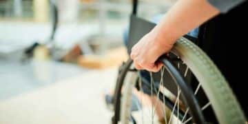 Trabajador en silla de ruedas ajusta la rueda: fin del despido automático por incapacidad permanente Ley 2/2025