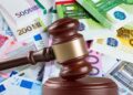 Mazo judicial sobre billetes de euro simboliza la multa de 2.451 € a una empresa por negligencia sanitaria tras infarto laboral