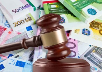 Mazo judicial sobre billetes de euro simboliza la multa de 2.451 € a una empresa por negligencia sanitaria tras infarto laboral