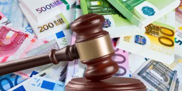 Mazo judicial sobre billetes de euro simboliza la multa de 2.451 € a una empresa por negligencia sanitaria tras infarto laboral