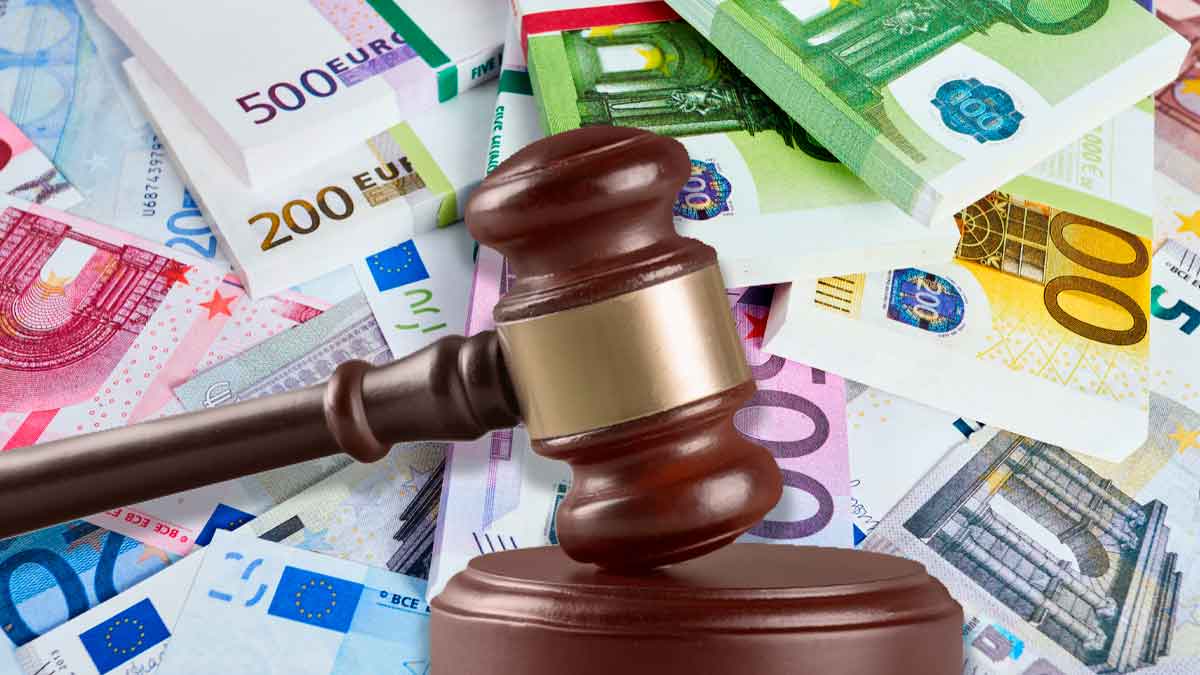 Mazo judicial sobre billetes de euro simboliza la multa de 2.451 € a una empresa por negligencia sanitaria tras infarto laboral