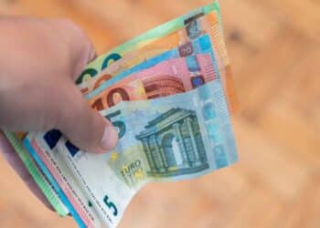 Persona mostrando billetes de euro, concepto de ayuda económica del Ingreso Mínimo Vital en 2025