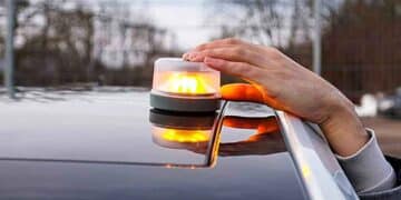 Conductor coloca la luz de emergencia V-16 sobre el techo del coche, obligatoria en 2026 y disponible gratis en promociones