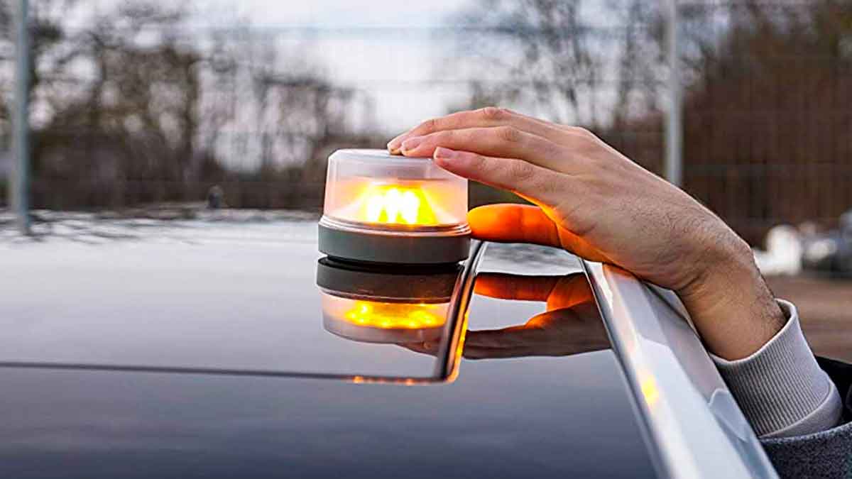 Conductor coloca la luz de emergencia V-16 sobre el techo del coche, obligatoria en 2026 y disponible gratis en promociones