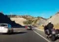 Motociclista circulando por el arcén en una autovía con tráfico denso, novedad normativa DGT 2025 sobre carril izquierdo