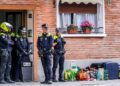 Policías municipales vigilan la entrada de una vivienda social con maletas y bolsas en la acera durante un desahucio por ocupación ilegal en Madrid