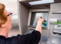 Jubilada sacando efectivo del cajero tras cobrar la paga extra de junio para pensionistas