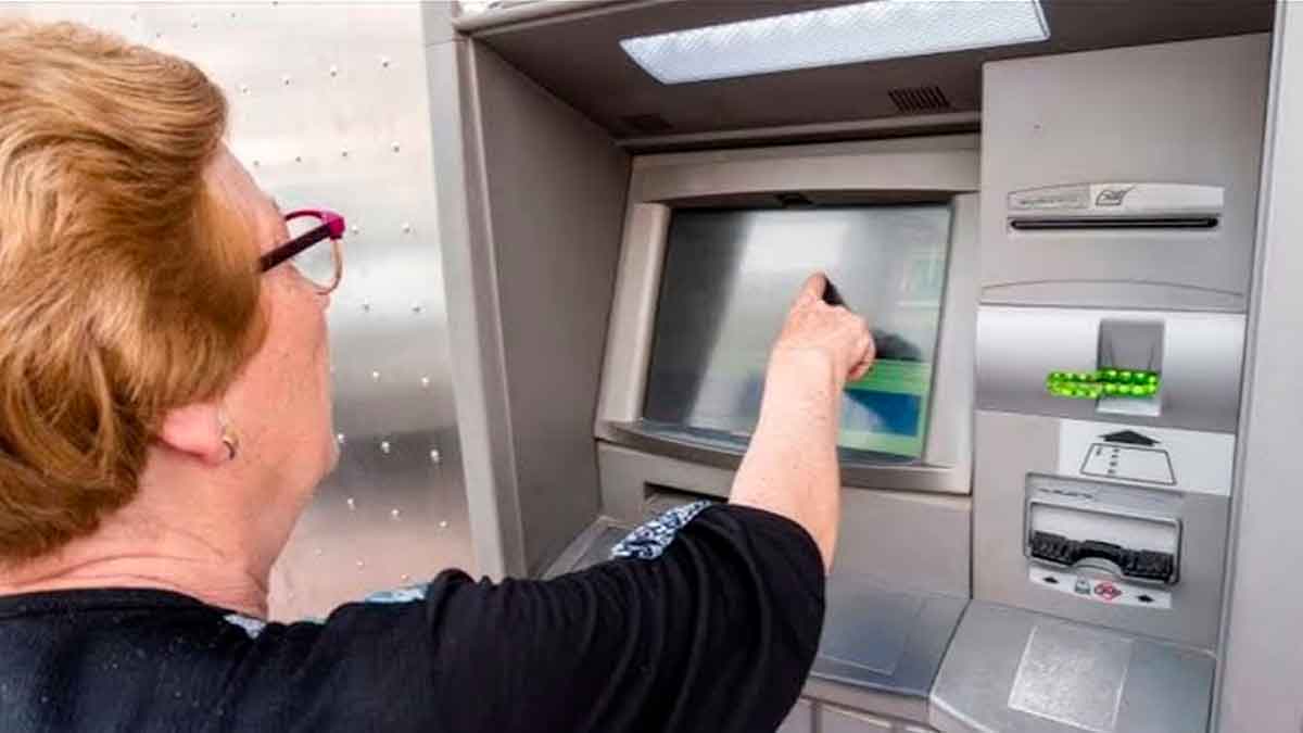 Jubilada sacando efectivo del cajero tras cobrar la paga extra de junio para pensionistas
