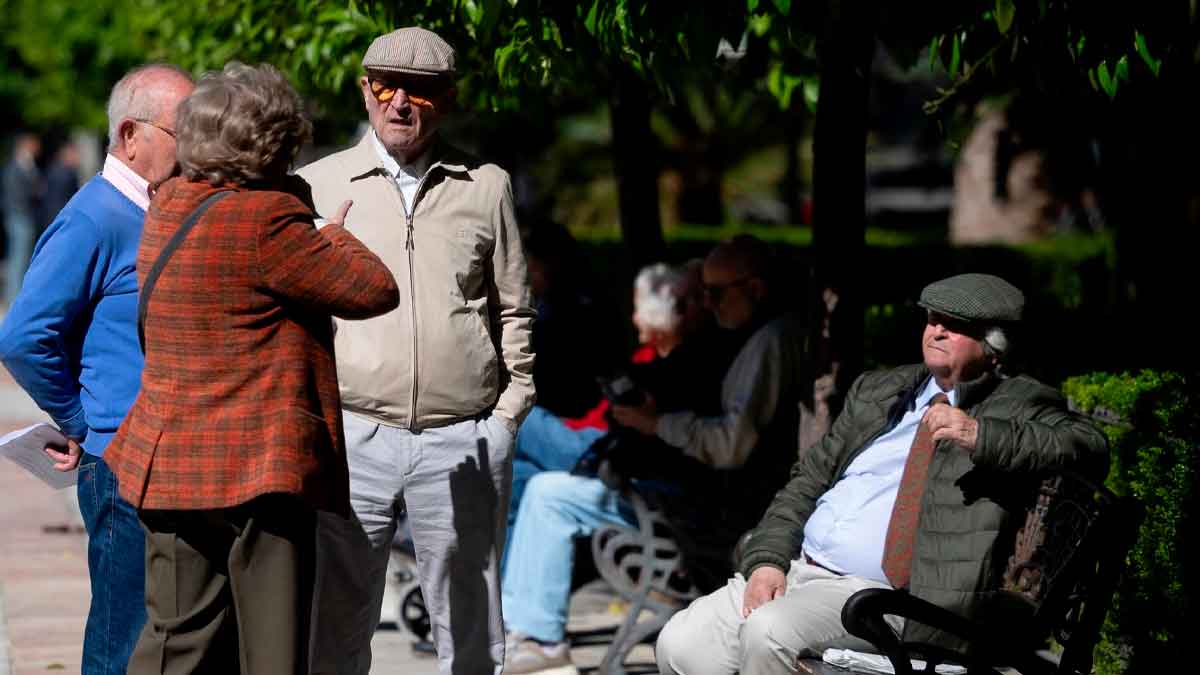 Grupo de jubilados vascos conversando en un parque, ilustrando la brecha territorial de pensiones que alcanza los 2.117 € mensuales