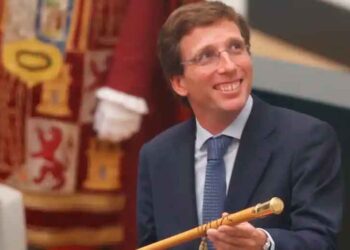 Político español sonriente con traje sosteniendo bastón de mando en acto oficial, ilustración sobre los salarios públicos de alcaldes y otros cargos políticos en España