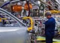 Trabajador en la línea de montaje de una fábrica automotriz de Stellantis durante el ensamblaje de carrocerías