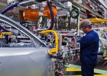 Trabajador en la línea de montaje de una fábrica automotriz de Stellantis durante el ensamblaje de carrocerías
