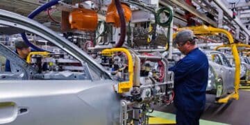 Trabajador en la línea de montaje de una fábrica automotriz de Stellantis durante el ensamblaje de carrocerías