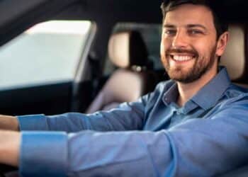 Conductor sonriente dentro de su coche tras conocer la sentencia que anula intereses abusivos en créditos de vehículo