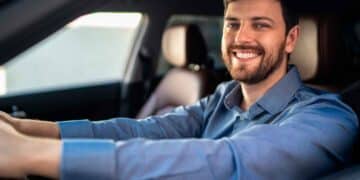 Conductor sonriente dentro de su coche tras conocer la sentencia que anula intereses abusivos en créditos de vehículo