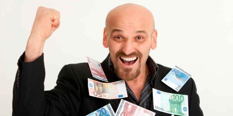 Hombre calvo sonriente cubierto de billetes de euro, simbolizando la ayuda de 600 € del SEPE por completar cursos oficiales