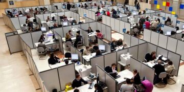 Funcionarios atendiendo a ciudadanos en una oficina pública; la nueva ley plantea suspender empleo y sueldo por retrasos reiterados