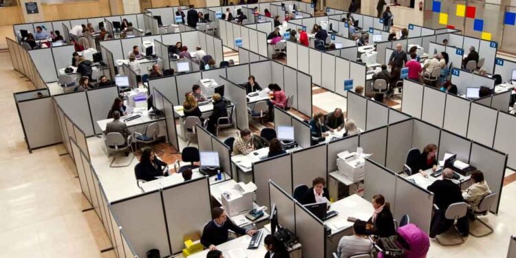 Funcionarios atendiendo a ciudadanos en una oficina pública; la nueva ley plantea suspender empleo y sueldo por retrasos reiterados