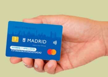 Mano sosteniendo la Tarjeta Familias Madrid 2025, ayuda de hasta 693 € mensuales para alimentos y transporte