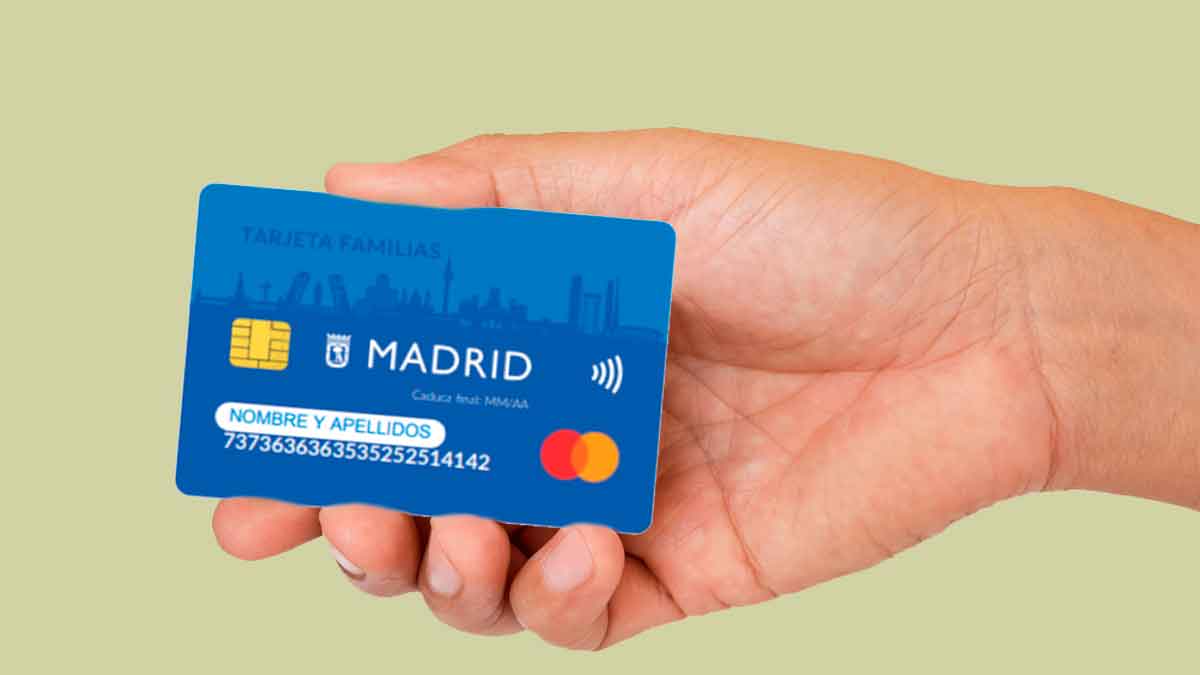 Mano sosteniendo la Tarjeta Familias Madrid 2025, ayuda de hasta 693 € mensuales para alimentos y transporte