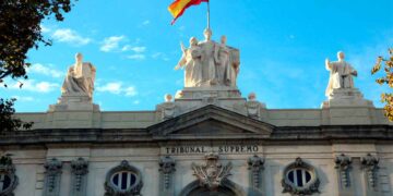 Fachada del Tribunal Supremo de España con la bandera nacional, epicentro de la sentencia que prohíbe imponer trabajo en fines de semana