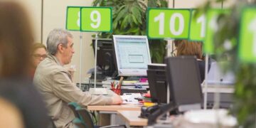 Ciudadano consulta con un funcionario el estado de su prestación en una oficina de la Seguridad Social