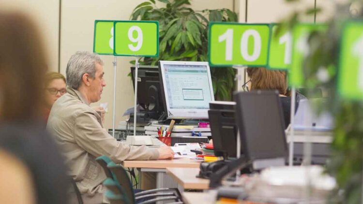 Ciudadano consulta con un funcionario el estado de su prestación en una oficina de la Seguridad Social